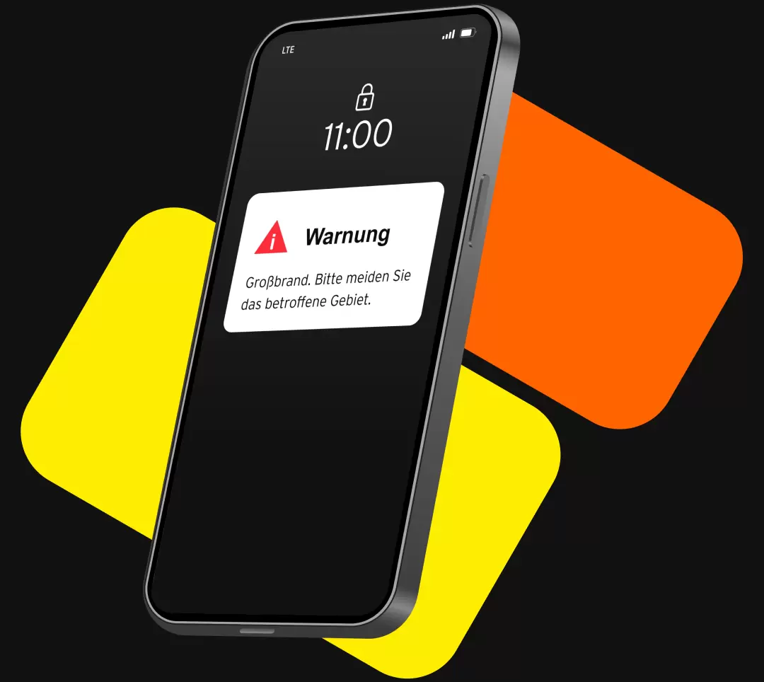 Beispielabbildung von einem Smartphone mit Sperrbildschirm, das folgende Warnmeldung zeigt: "Warnung! Großbrand. Bitte meiden Sie das betroffene Gebiet."